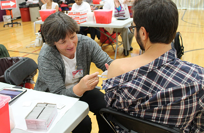 Professor Mary Hayney (Pharmacy Practice Division) provides a vaccination to a UW-Madison student.