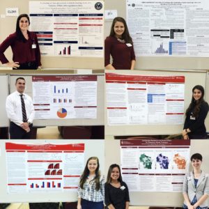 PDC members pose next to their research posters
