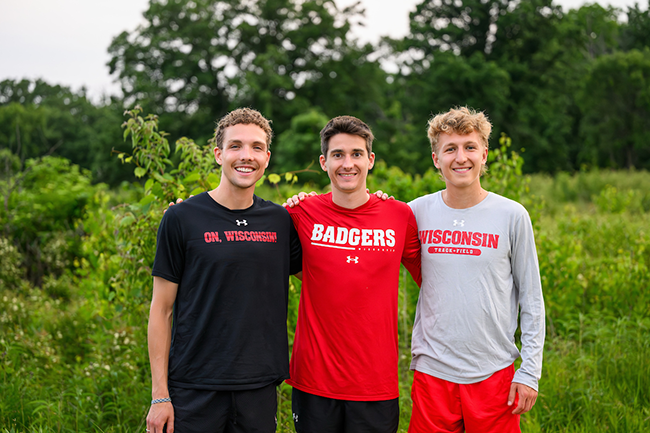 Three UW cross country runners pose together in the Arboretum