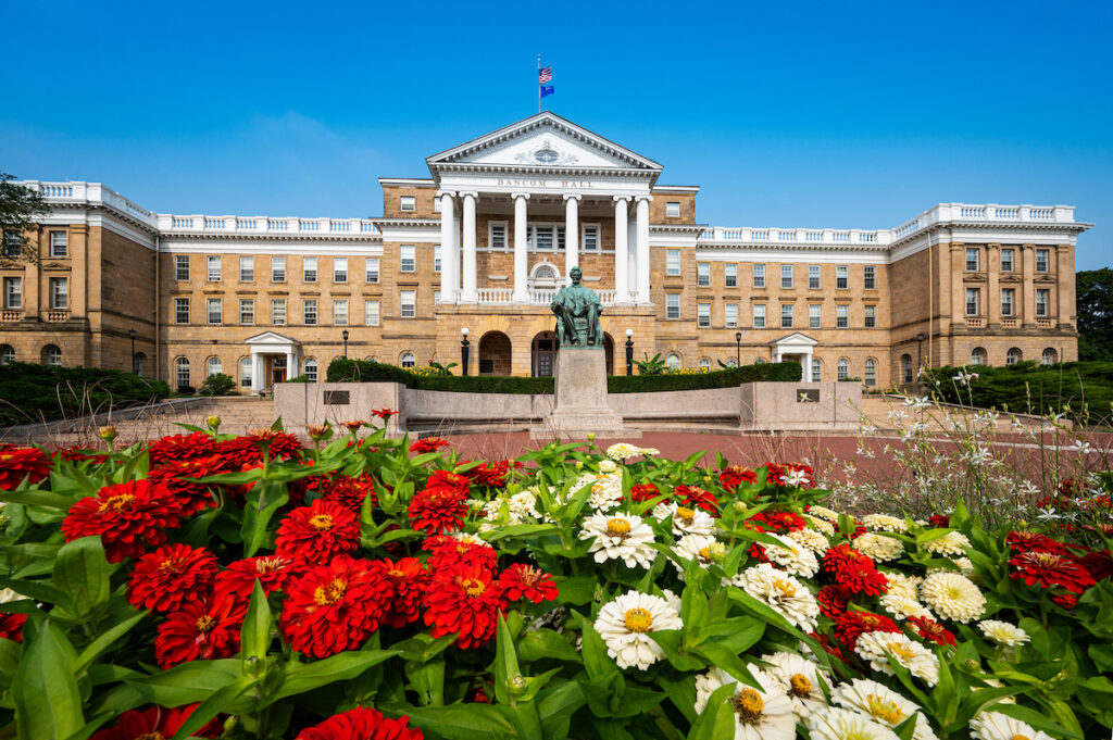 Bascom Hall is framed with red and white zinnia blooms during summer at the University of Wisconsin-Madison on August 10, 2021. (Photo by Bryce Richter / UW-Madison)