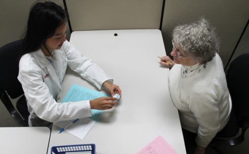 A pharmacy student does a practice patient consultation in communications lab