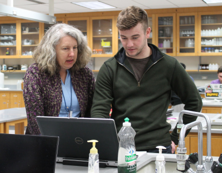 Professor Rosen helps a student analyze his data during lab