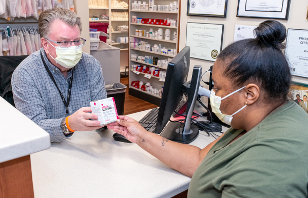 Pharmacist John Weitekamp counsels a patient on how to use a medication