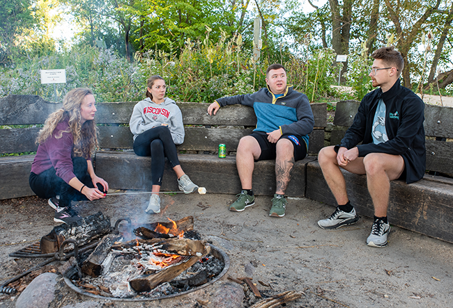 Members of the Pharmacy PHIT org hang out and chat over s'mores at Picnic Point