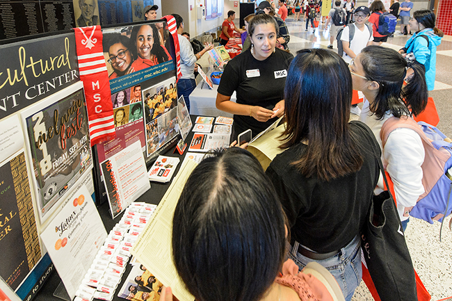 Students check out the Multicultural Student Center booth during the Fall Student Organization Fair at the Kohl Center