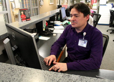 A pharmacy resident enters data in a clinic computer