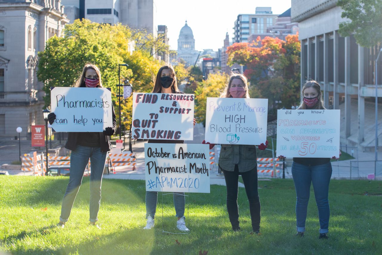 Group photo of students holding signs on Bascom hill